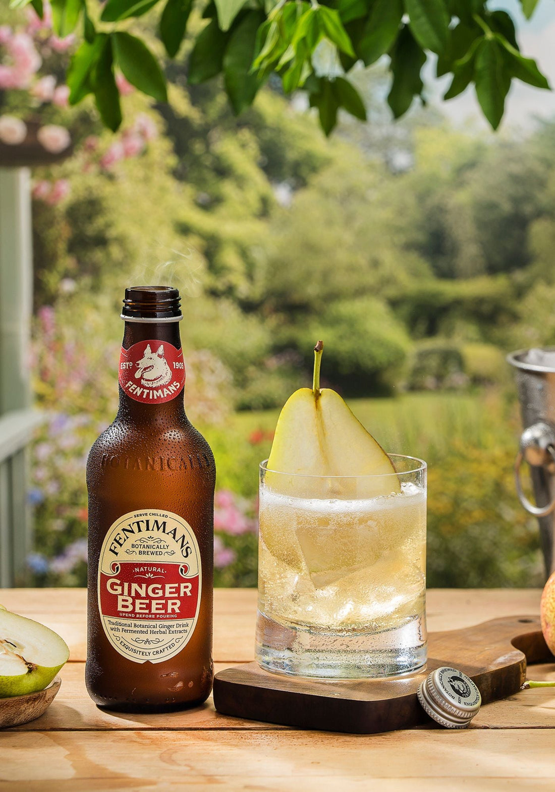 The 1905 cocktail made with Fentimans Ginger Beer in a short glass with a sliced pear in a garden setting